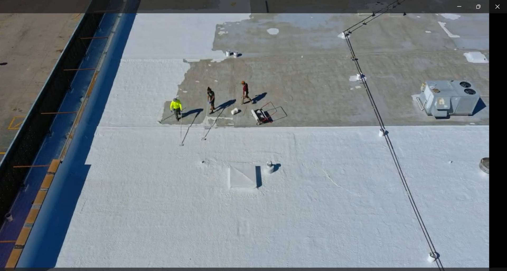 Commercial flat roof with silicone coating being applied